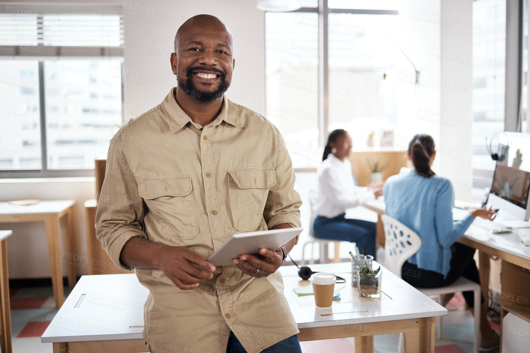 Buy stock photo Shot of a mature businessman using a digital tablet in a modern office