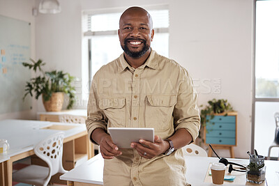 Buy stock photo Shot of a mature businessman using a digital tablet in a modern office