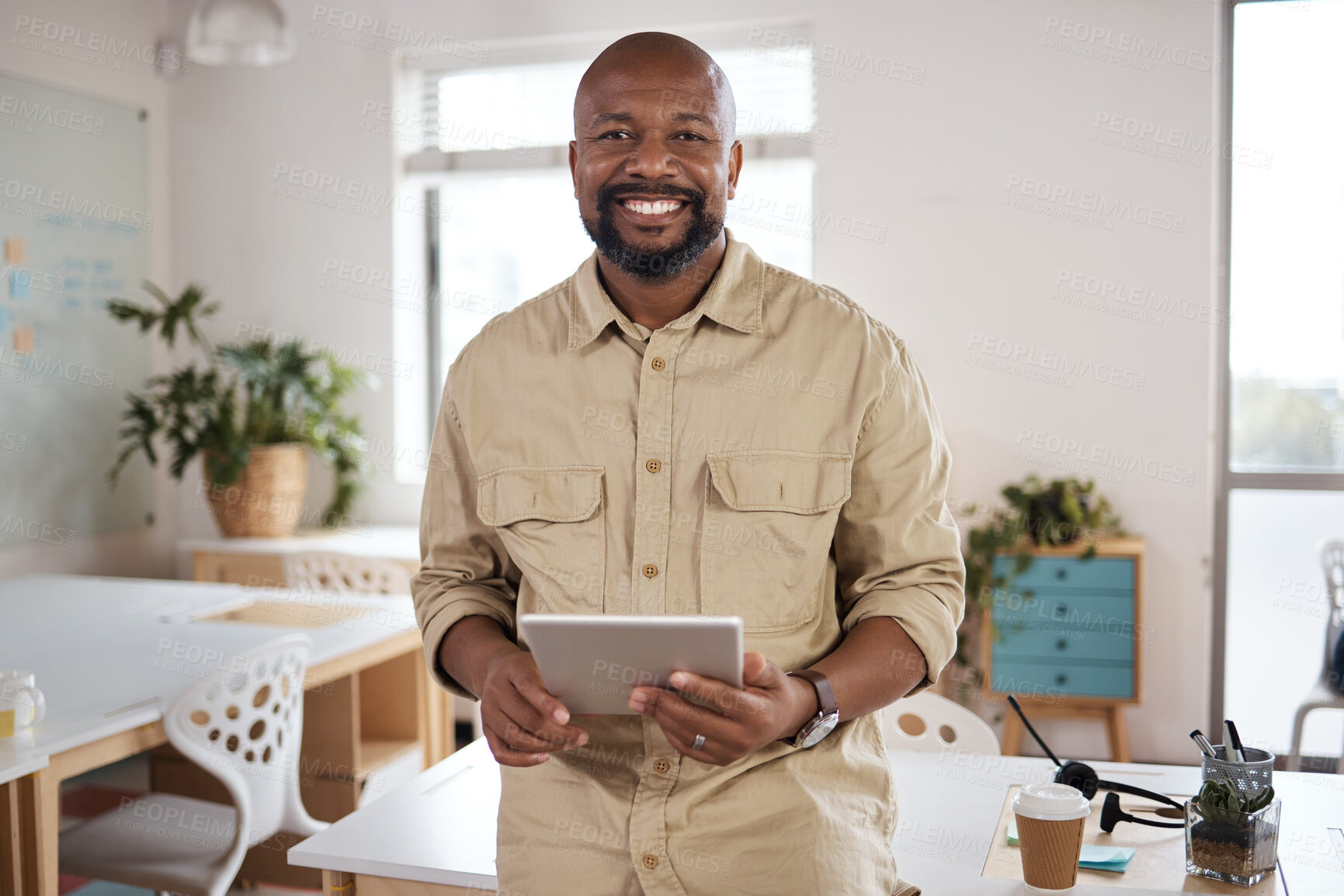 Buy stock photo Shot of a mature businessman using a digital tablet in a modern office