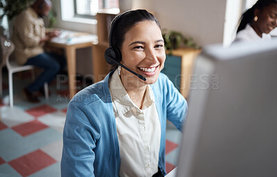 Buy stock photo Shot of a young businessman using a headset and computer in a modern office