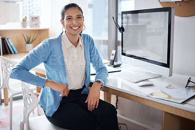 Buy stock photo Shot of a young businesswoman using a computer at her desk in a modern office