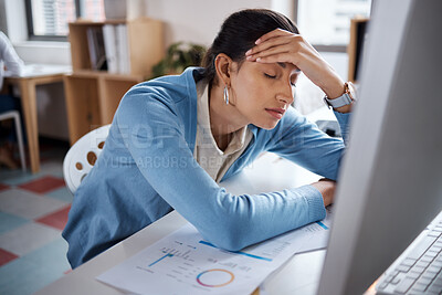 Buy stock photo Shot of a young businesswoman looking stressed while using a laptop at her desk in a modern office