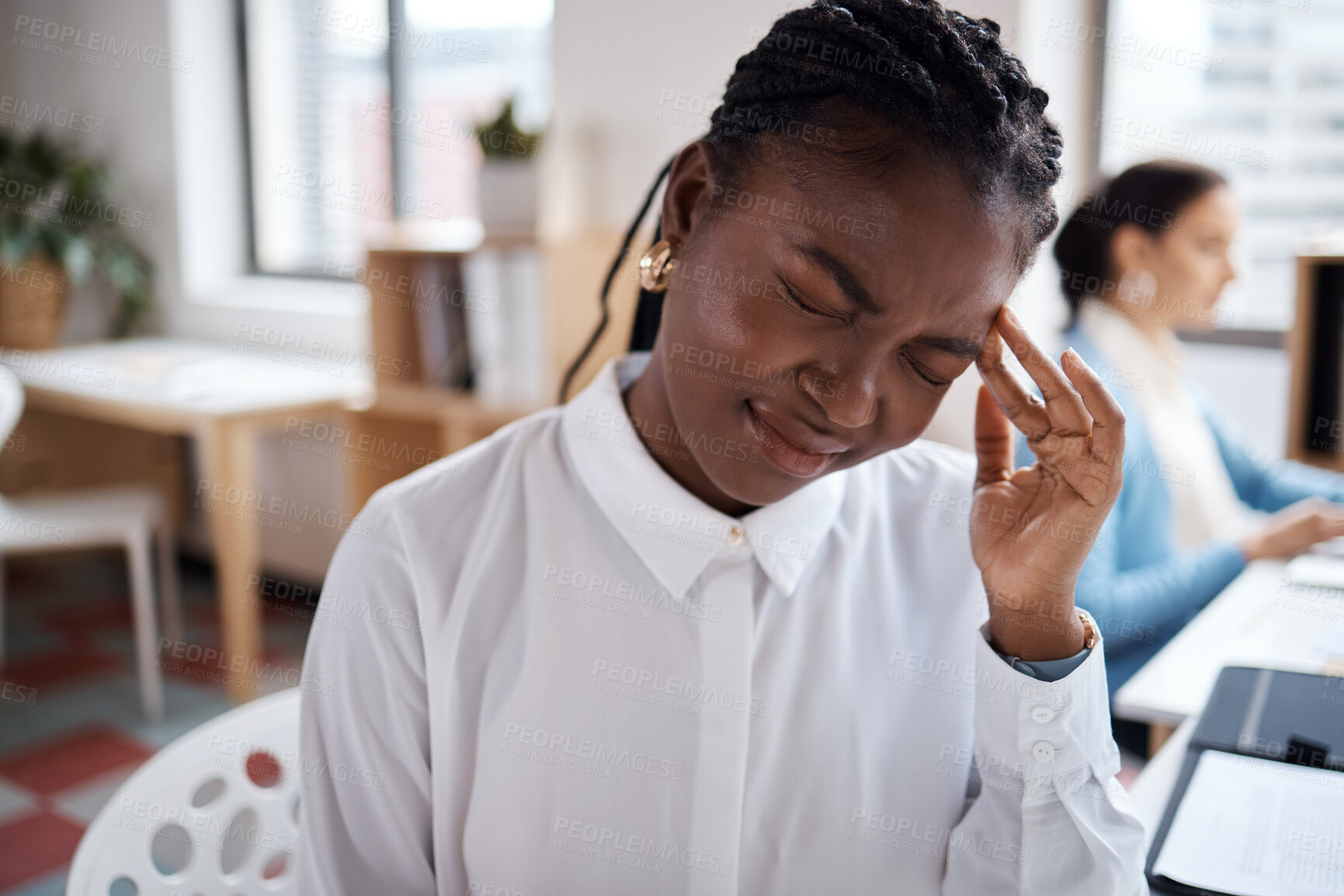 Buy stock photo Shot of a young businesswoman looking stressed while working at her desk in a modern office