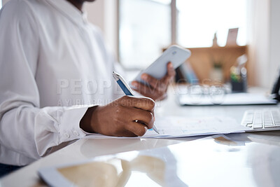 Buy stock photo Shot of an unrecognisable businesswoman filling out paperwork and using a smartphone at her desk in a modern office