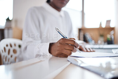 Buy stock photo Shot of an unrecognisable businesswoman filling out paperwork at her desk in a modern office