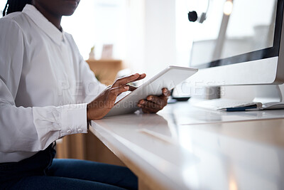 Buy stock photo Shot of an unrecognisable businesswoman using a digital tablet at her desk in a modern office