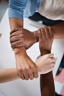 Buy stock photo Shot of a group of businesspeople linking arms in solidarity in a modern office