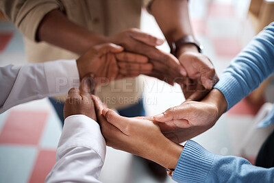 Buy stock photo Shot of a group of businesspeople joining hands in solidarity in a modern office