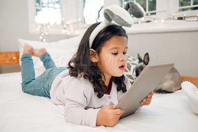 Buy stock photo Kid, pet and tablet on bed for relax, responsibility and online media or animal care tutorial. Little girl, bunny or technology in home for development, cute rabbit videos and feeding requirements