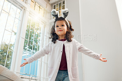 Buy stock photo Happy, child and bunny ears costume at home with playing and fantasy game with fun. Young girl, kid bedroom and cognitive development of skills and creativity with silly dancing by a window below