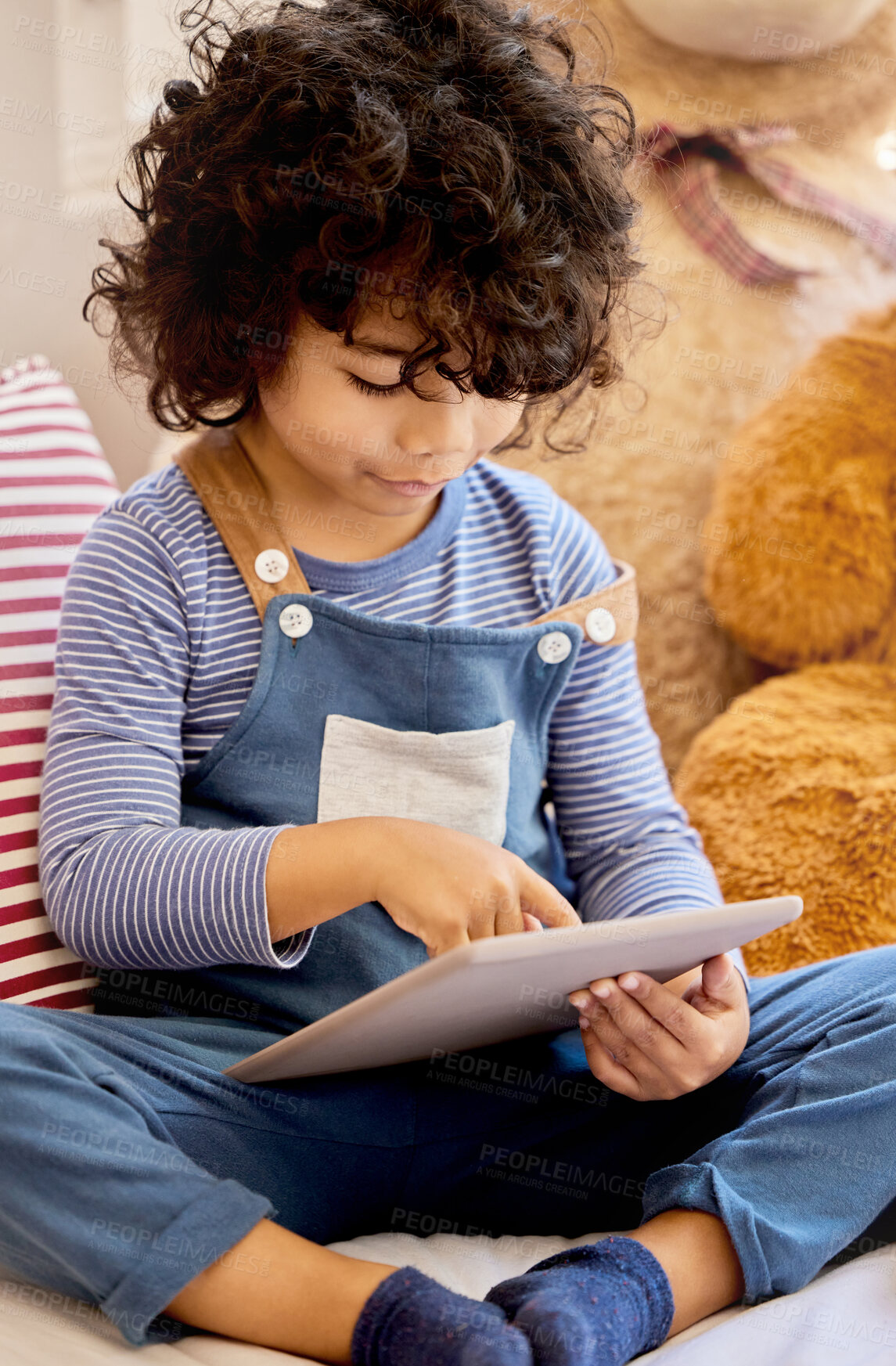 Buy stock photo Shot of a little boy using a digital tablet at home