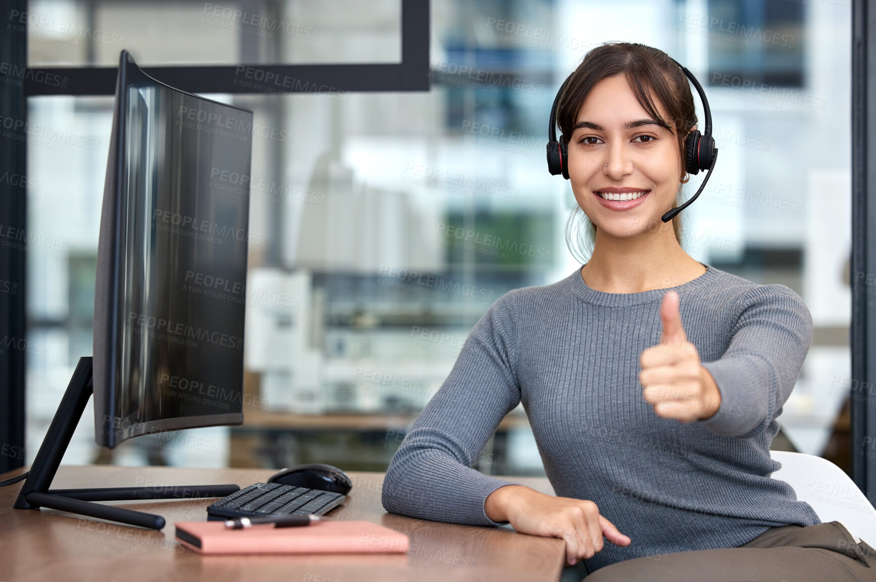 Buy stock photo Thumbs, woman with headset and on a computer at her desk in a workplace office for success. Call center or customer service, crm and online communication with female person for support at her work