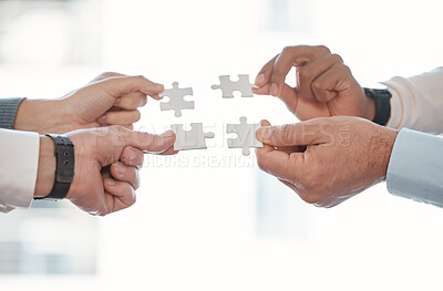 Buy stock photo Cropped shot of four unrecognizable businesspeople building a puzzle in the office