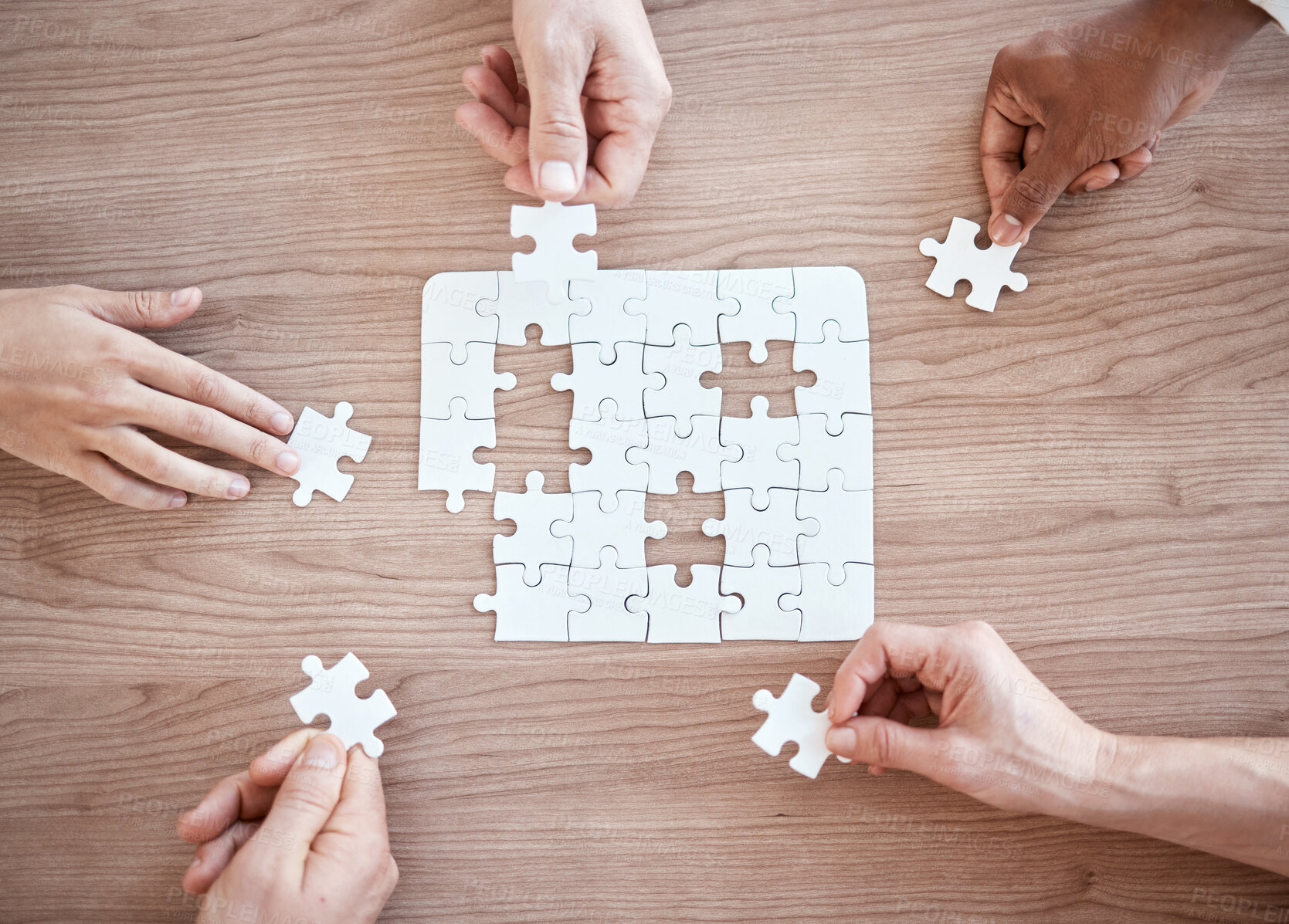 Buy stock photo Cropped shot of five unrecognizable businesspeople building a puzzle in the office