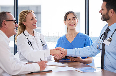 Buy stock photo Shot of two doctors shaking hands in a meeting at a hospital