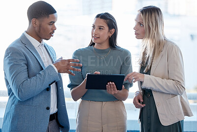 Buy stock photo Shot of a group of businesspeople using a digital tablet together in an office