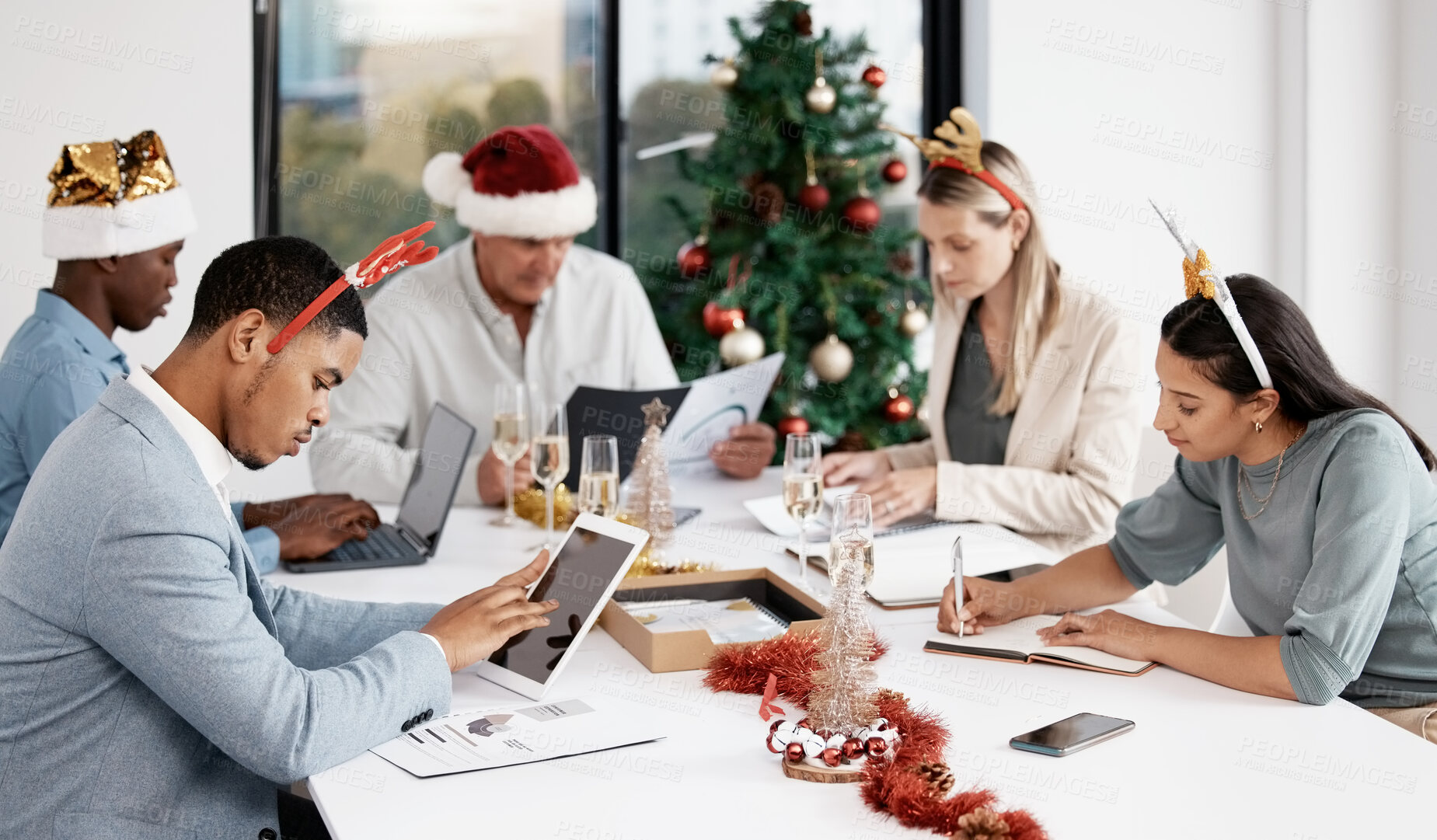 Buy stock photo Business people, Christmas and meeting in office with documents, laptop and notebook with festive decoration. Men, women and teamwork at xmas with celebration, collaboration and writing at company