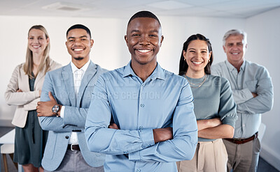 Buy stock photo Portrait of a confident young businessman standing with his arms crossed in an office with his colleagues behind him