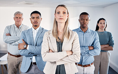 Buy stock photo Portrait of a confident businesswoman standing with her arms crossed in an office with her colleagues behind her