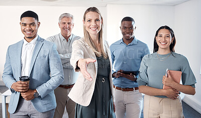 Buy stock photo Portrait of a mature businesswoman extending a handshake while standing alongside her colleagues in an office