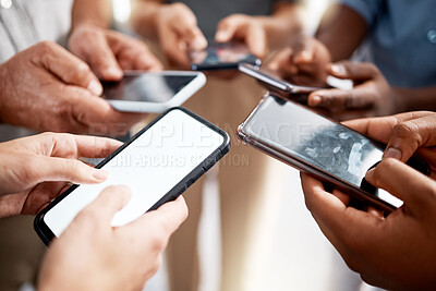 Buy stock photo Shot of a group of unrecognisable businesspeople using their smartphones in a modern office
