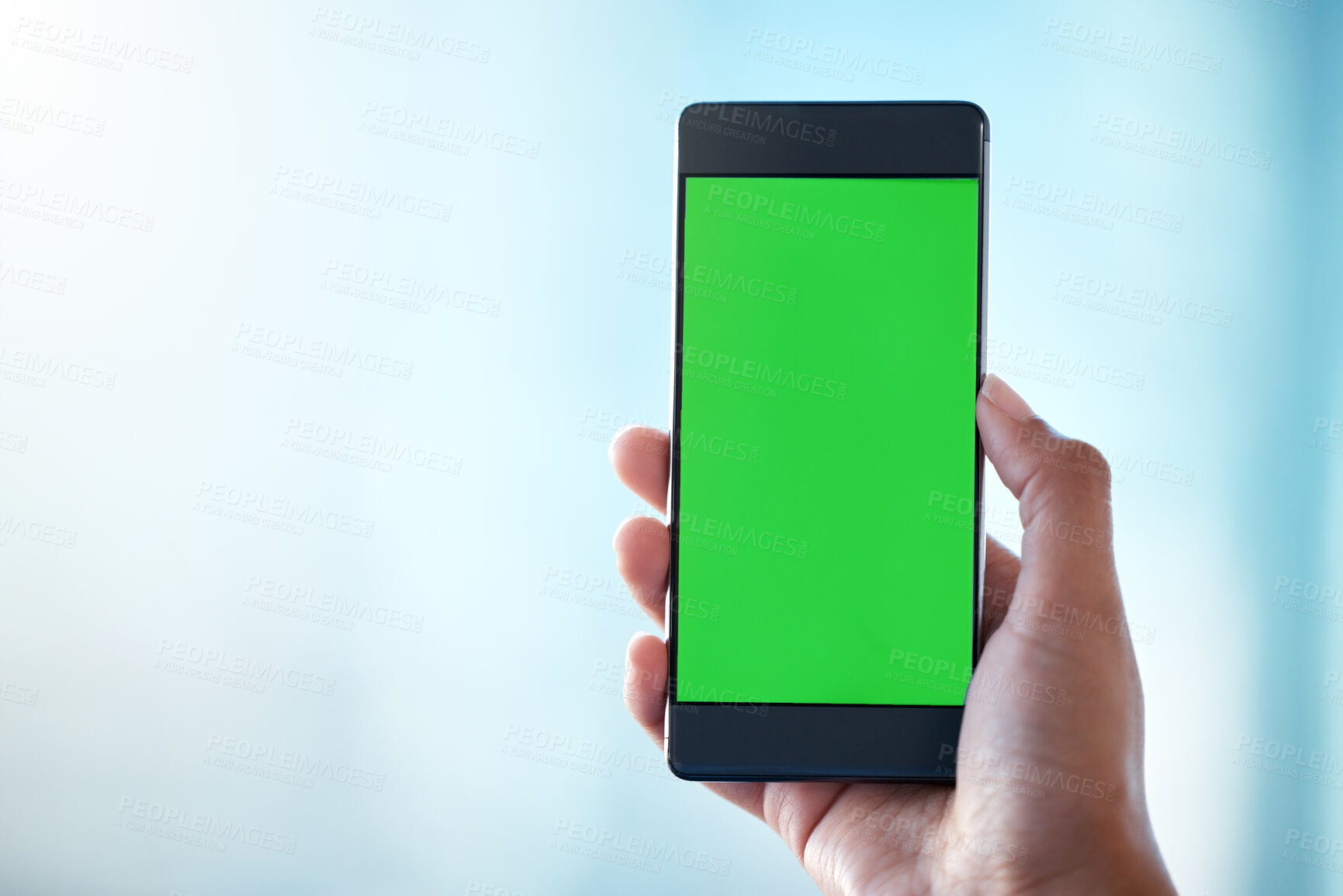 Buy stock photo Shot of an unrecognisable person using a smartphone with a green screen on it