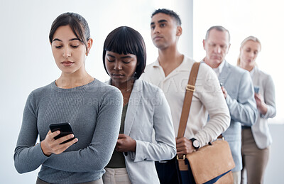 Buy stock photo Shot of a group of new employees waiting in a line to complete their interview