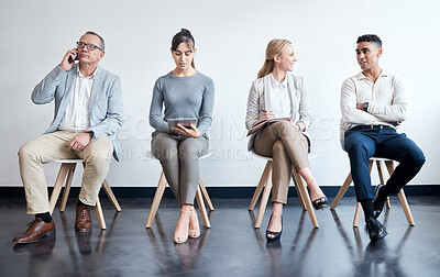 Buy stock photo Shot of a group of businesspeople waiting in line at an office