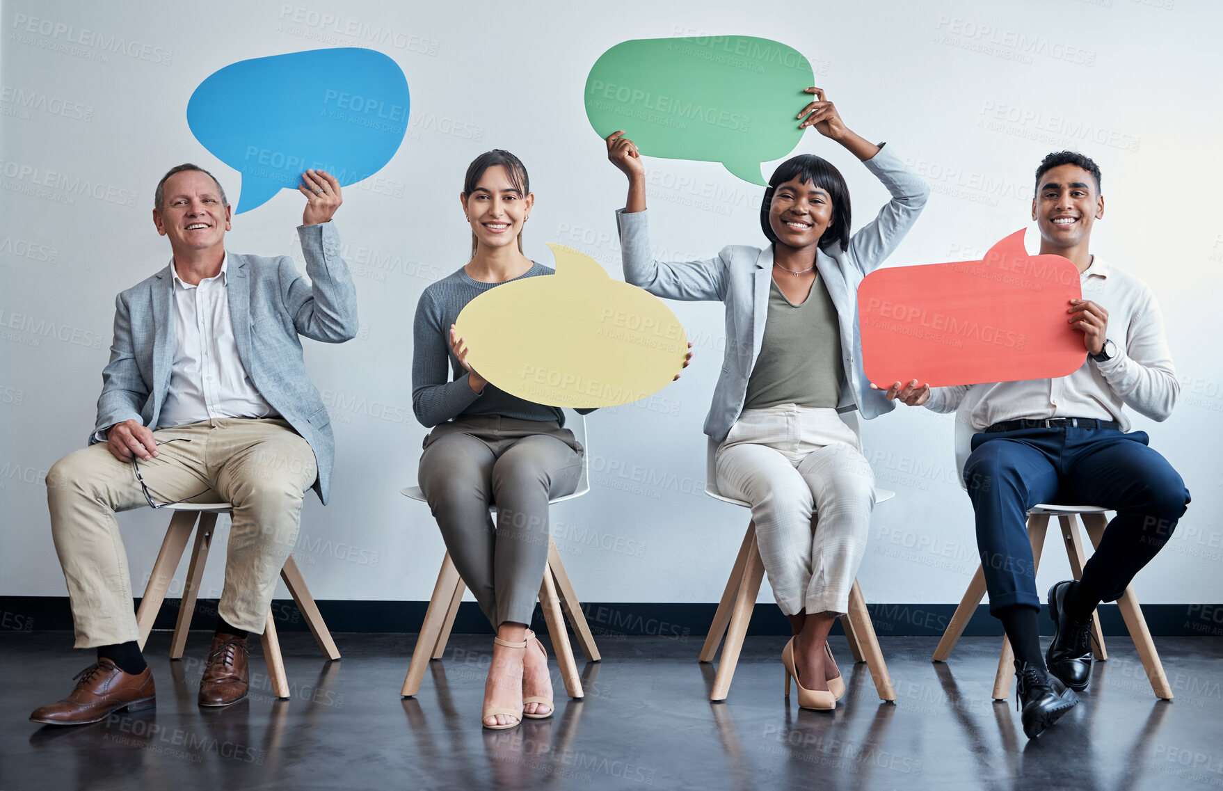 Buy stock photo Shot of a group of businesspeople holding speech bubbles while waiting in line at an office