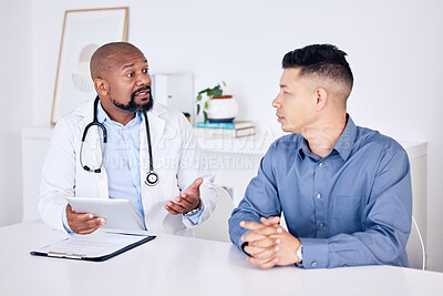 Buy stock photo Shot of a mature male doctor having a consultation with a patient at a hospital