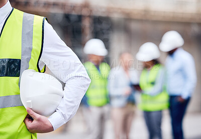 Buy stock photo Shot of an unrecognizable architect holding a helmet at a building site