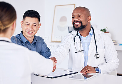 Buy stock photo Shot of two doctors shaking hands at a clinic