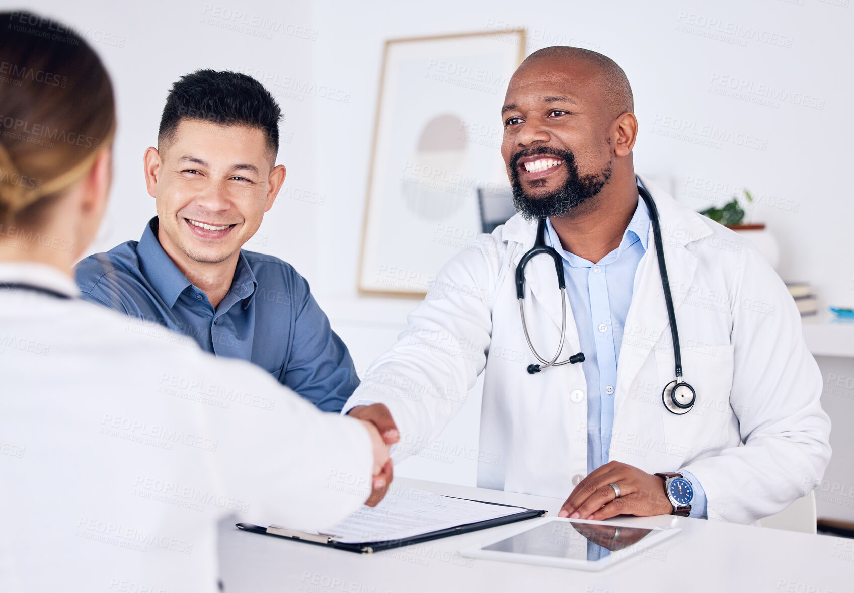 Buy stock photo Shot of two doctors shaking hands at a clinic