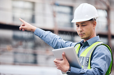 Buy stock photo Shot of a mature male architect using a digital tablet at a building site