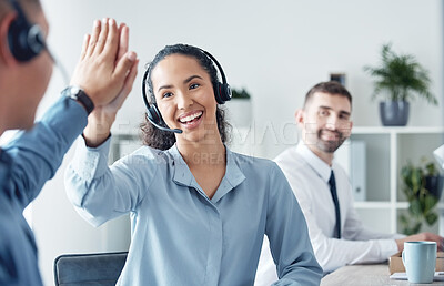 Buy stock photo Shot of two call centre agents giving each other a high five in an office