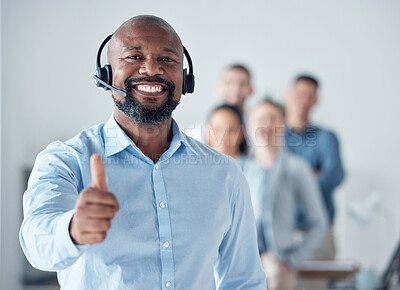 Buy stock photo Portrait of a mature call centre agent showing thumbs up in an office with his colleagues in the background