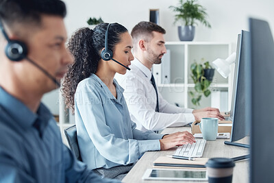 Buy stock photo Shot of a young call centre agent working alongside her colleagues in an office