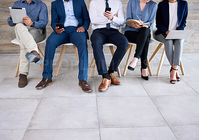 Buy stock photo Shot of a group of unrecognizable businesspeople sitting in a line at an office