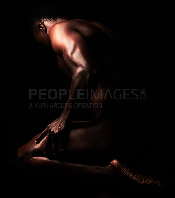 Buy stock photo Artistic shot of a muscular young man posing in studio against a dark background