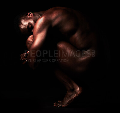 Buy stock photo Artistic shot of a muscular young man posing in studio against a dark background