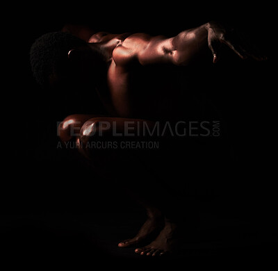 Buy stock photo Artistic shot of a muscular young man posing in studio against a dark background