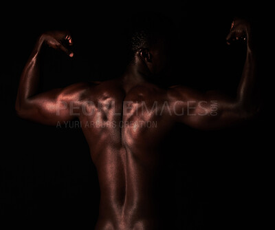 Buy stock photo Artistic shot of a muscular young man posing in studio against a dark background