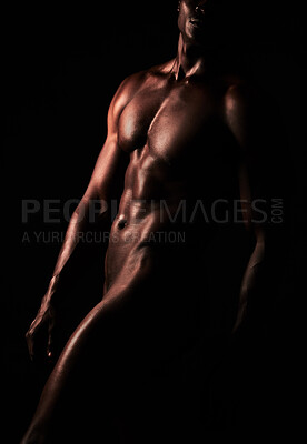 Buy stock photo Artistic shot of a muscular young man posing in studio against a dark background