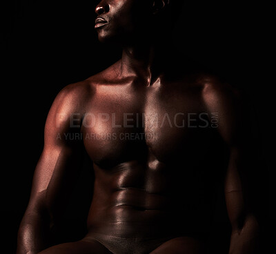 Buy stock photo Artistic shot of a muscular young man posing in studio against a dark background