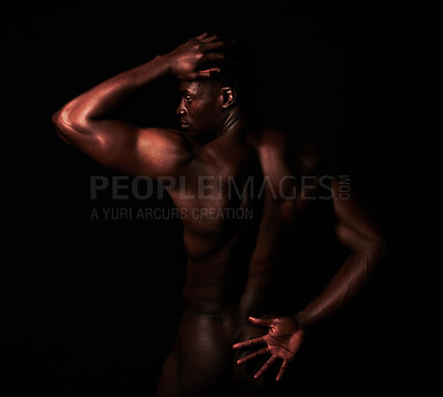 Buy stock photo Artistic shot of a muscular young man posing in studio against a dark background