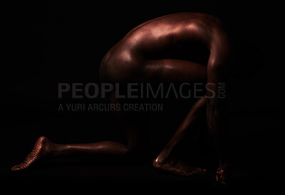 Buy stock photo Artistic shot of a muscular young man posing in studio against a dark background