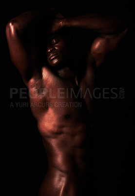 Buy stock photo Artistic shot of a muscular young man posing in studio against a dark background