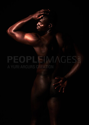 Buy stock photo Artistic shot of a muscular young man posing in studio against a dark background