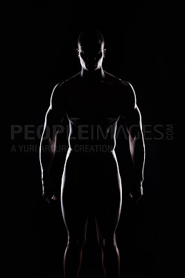 Buy stock photo Artistic shot of a muscular young man posing in studio against a dark background