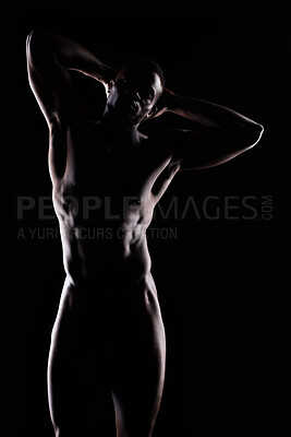 Buy stock photo Artistic shot of a muscular young man posing in studio against a dark background